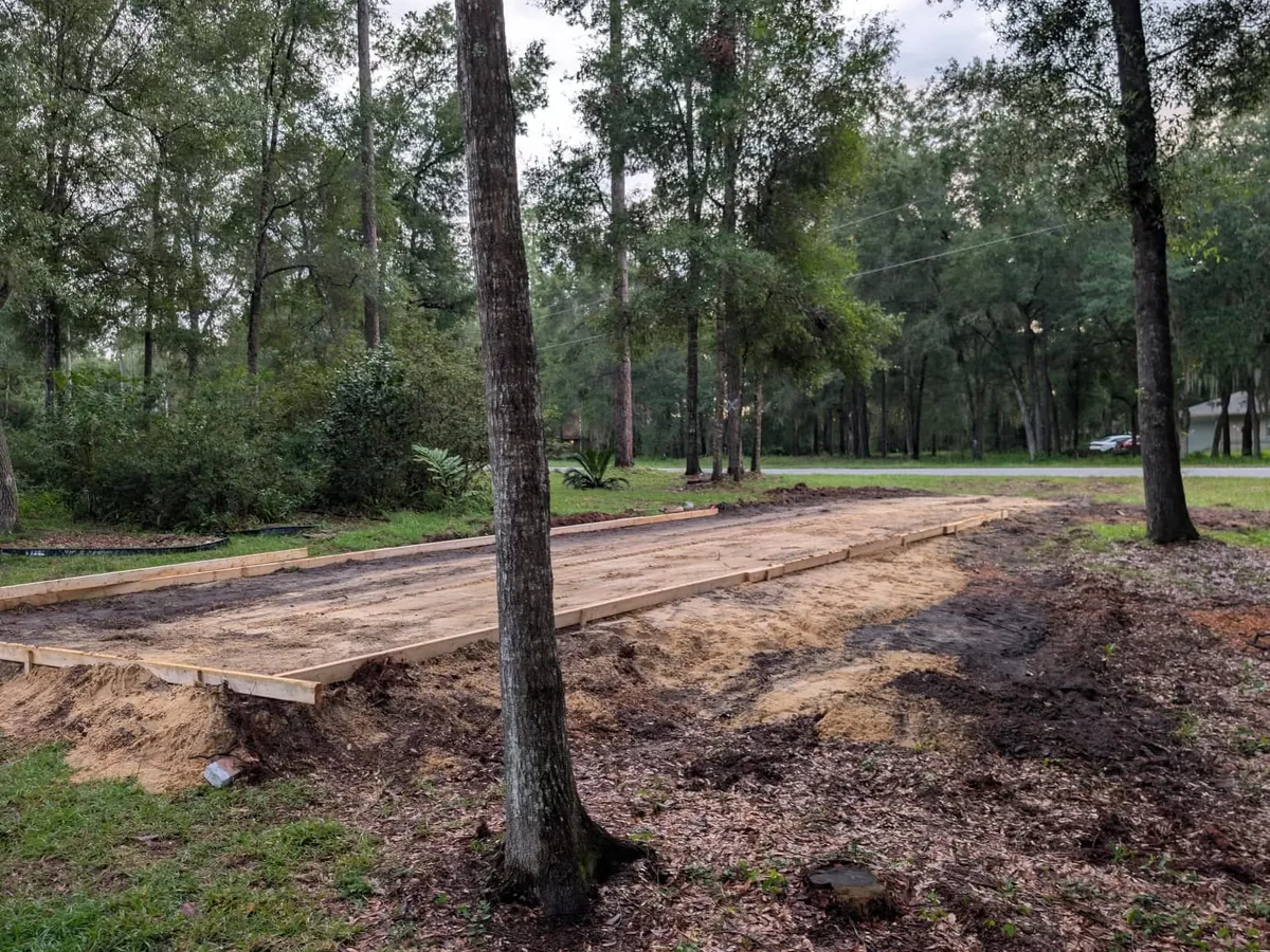 Wood forms set on a graded sand pad ready for a concrete pour