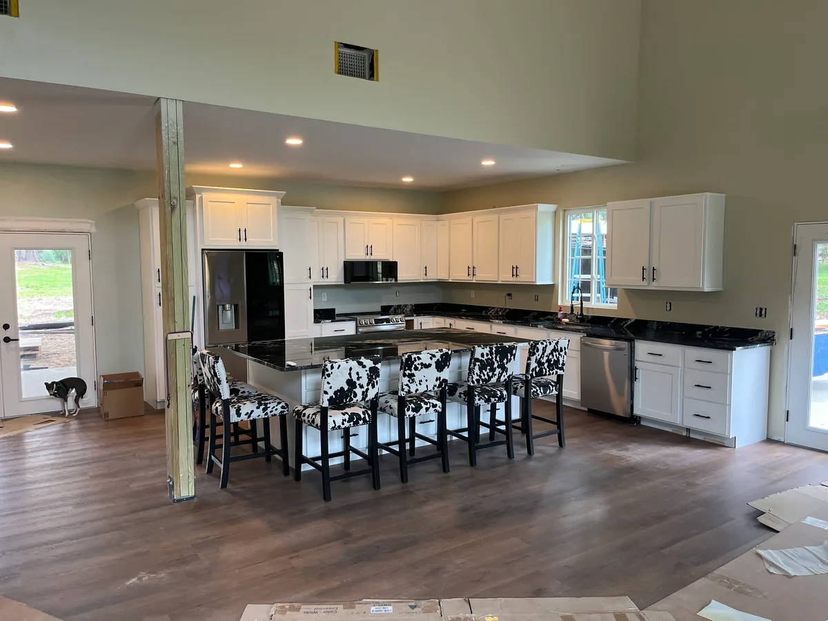 Finished kitchen with white shaker cabinets, dark countertops and a new range