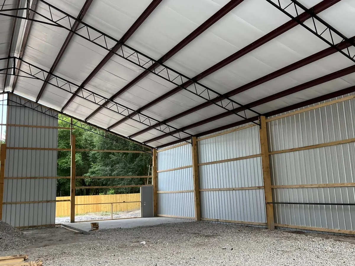 Metal building interior with steel trusses, red iron purlins and an insulated liner