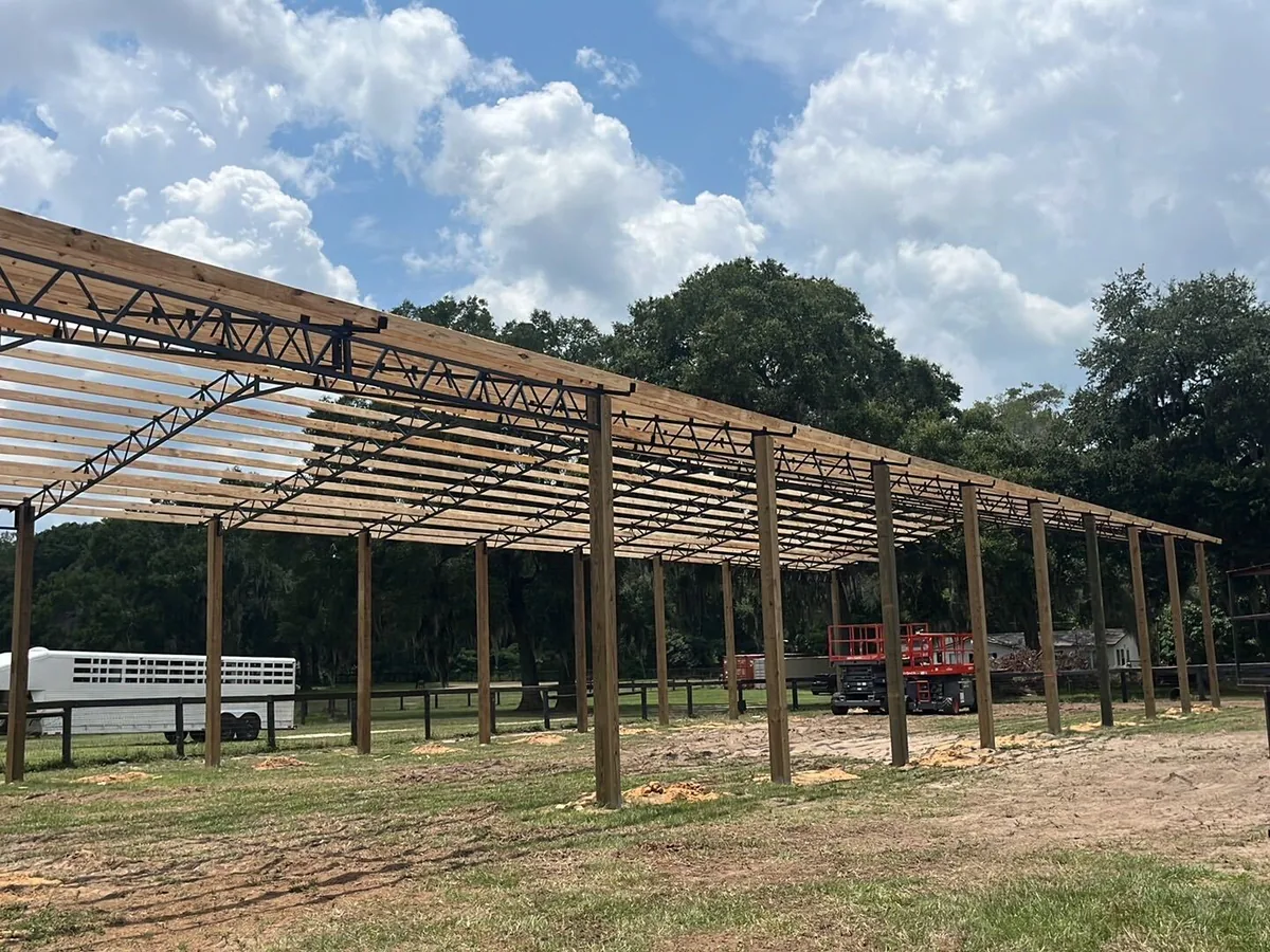 Pole barn frame with steel trusses and purlins going up